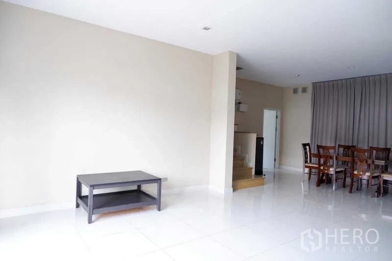 บ้าน ขายในLat Krabang, Bangkok - มุมห้องนั่งเล่นเชื่อมส่วนทานอาหารและบันได ผนังสีขาวสะอาด