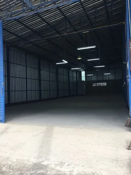 คลังสินค้า ให้เช่าในBang Kapi, Bangkok - ภายในโกดังย่านบางกะปิ เพดานสูง โครงเหล็ก ไฟสว่าง พื้นคอนกรีตเรียบ หลังประตูม้วนสีน้ำเงิน