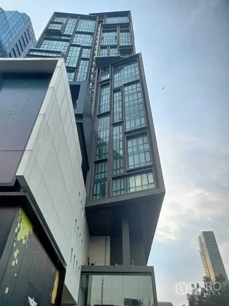 คอนโด ให้เช่าในWatthana, Bangkok - อาคารคอนโดมิเนียมไฮไรส์สมัยใหม่ มุมมองจากพื้นถนน โดดเด่นด้วยผนังกระจกทรงเหลี่ยม.