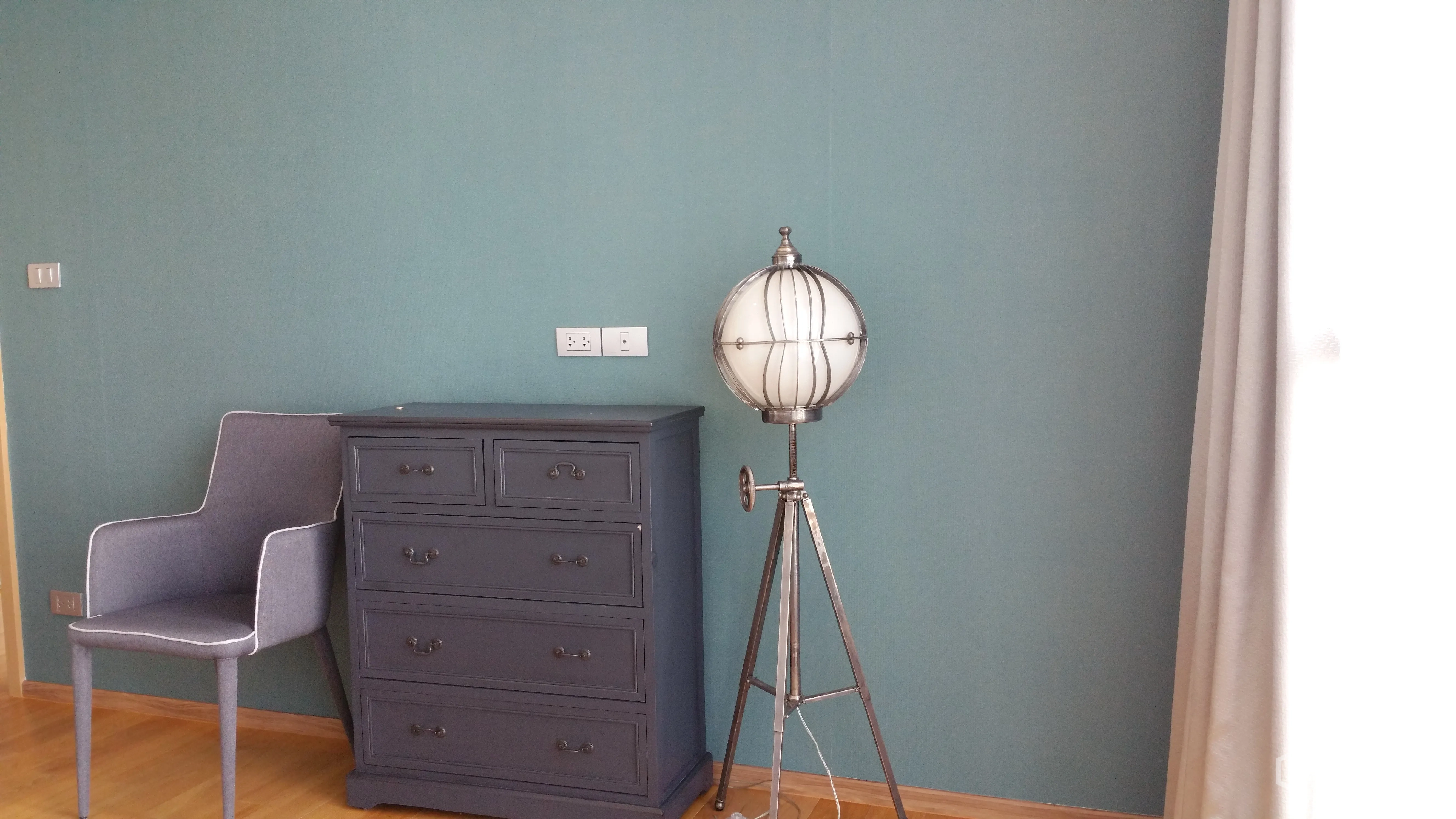 คอนโด ให้เช่าหรือขายในWatthana, Bangkok - มุมห้องนอนพร้อมตู้ลิ้นชักสีเทา เก้าอี้ผ้า และโคมไฟตั้งพื้นแบบขาตั้ง