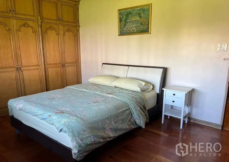 ทาวน์เฮาส์ ให้เช่าในKhlong Toei, Bangkok - ห้องนอนพร้อมเตียงคู่ ตู้เสื้อผ้าบิวท์อินไม้ และโต๊ะข้างเตียง