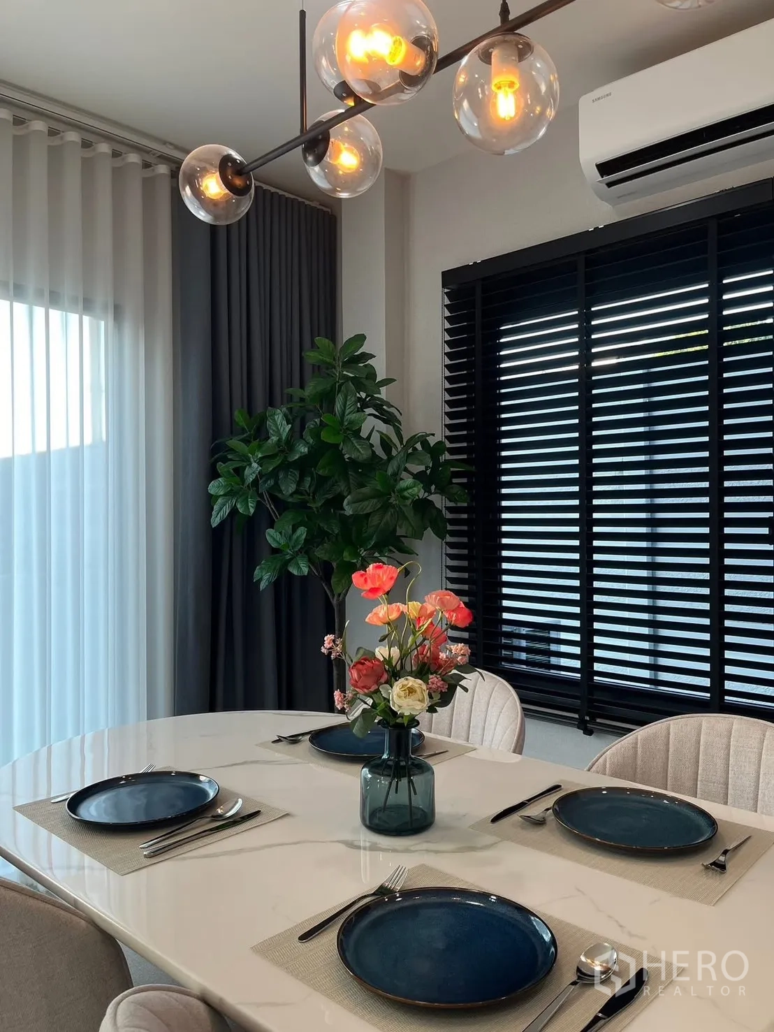 Detached House for rent in Bang Phli, Samut Prakan - Close-up of marble-top dining table set for four under globe pendant lights.