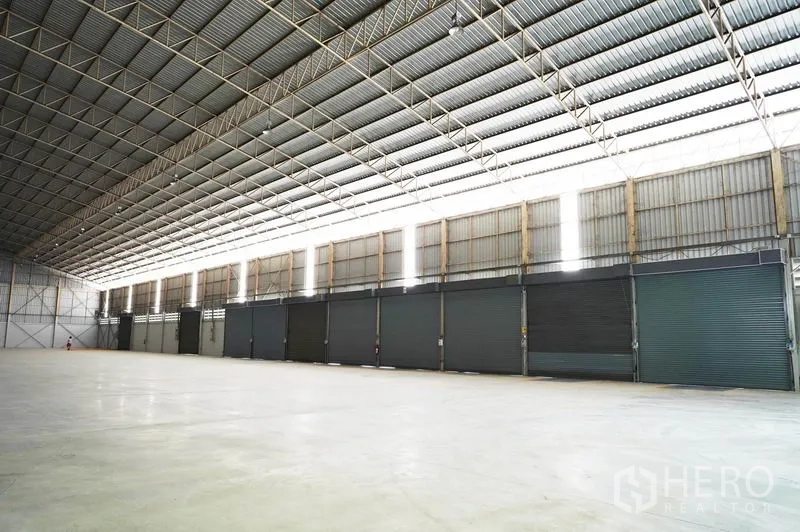 คลังสินค้า ให้เช่าในSi Racha, Chon Buri - ภายในโกดังกว้างขวาง โครงหลังคาเหล็กสูง หลายประตูม้วน และพื้นคอนกรีตขัดมัน