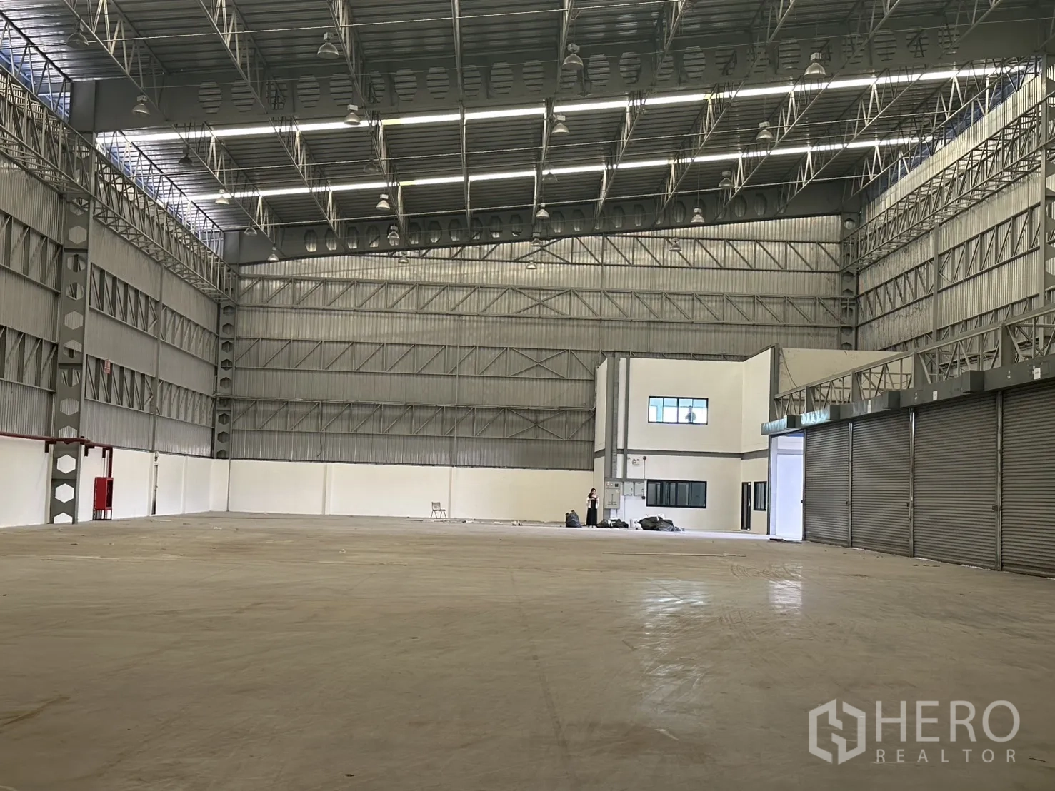 Warehouse for rent in Lat Krabang, Bangkok - Steel-truss high-bay interior with bright strip lighting and concrete floor.