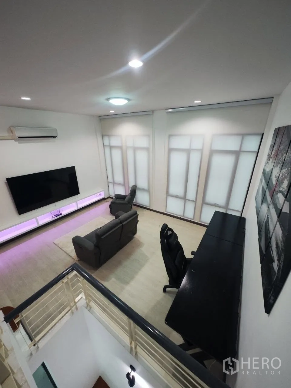 家庭办公室 for rent in Bang Na, Bangkok - 宽敞起居区，设沙发、大屏电视墙、书桌与筒灯照明。