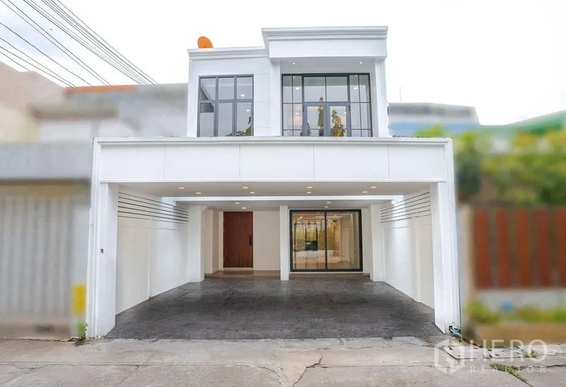 Townhouse for sale - Modern two-storey townhouse facade with large windows and a covered carport.