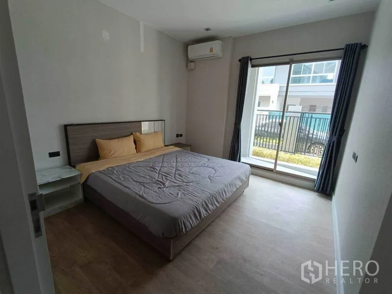 Detached House for rent in Bueng Kum, Bangkok - Ground-floor guest bedroom with air conditioner and sliding door opening to the patio.