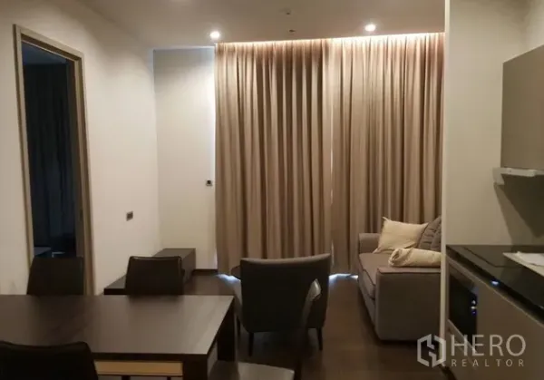 คอนโด ให้เช่าหรือขายในWatthana, Bangkok - พื้นที่นั่งเล่นและรับประทานอาหารแบบโอเพ่นแปลน พร้อมครัวขนาดกะทัดรัดและไฟดาวน์ไลท์