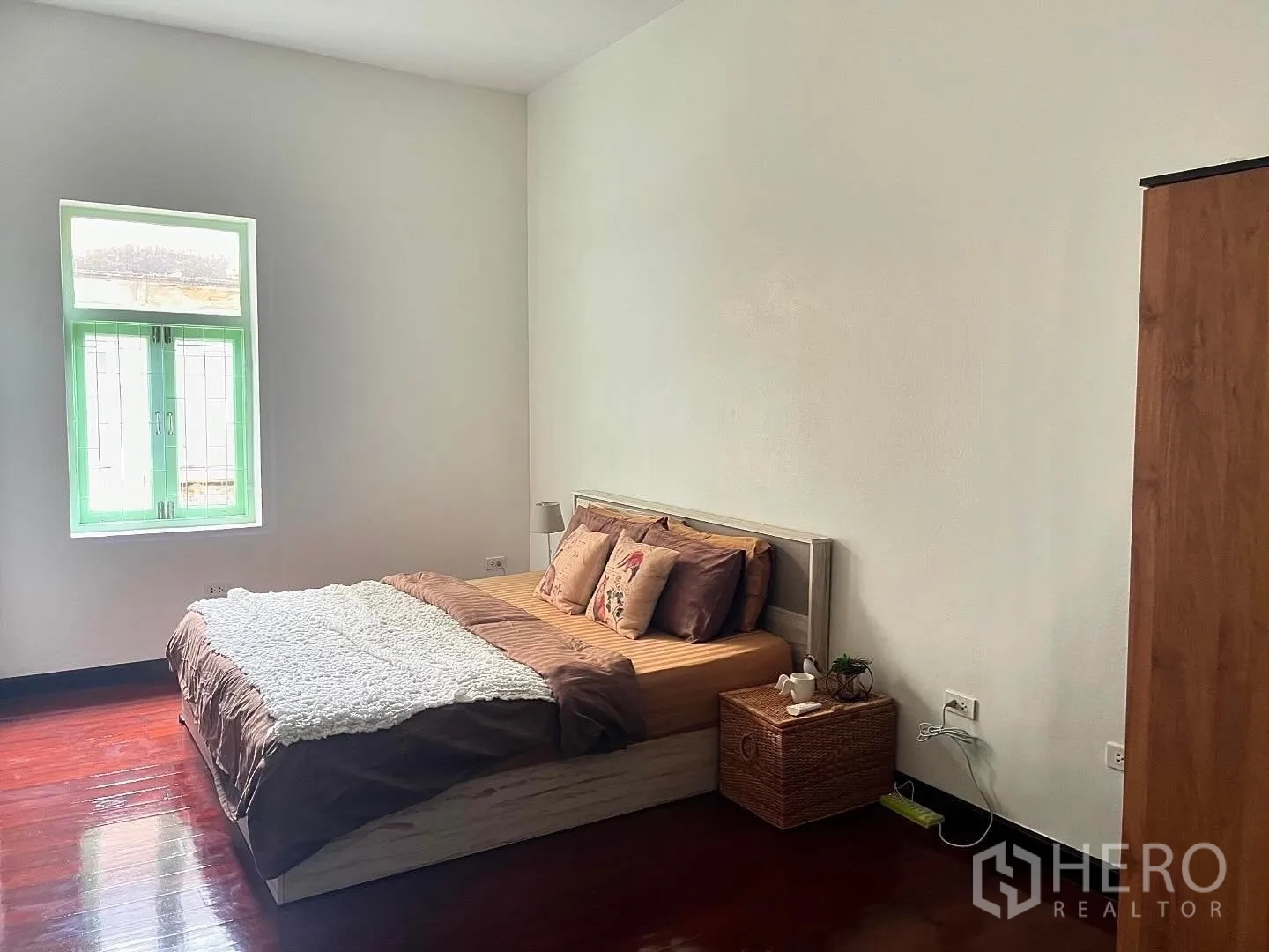 Shophouse for rent in Bang Rak, Bangkok - Bright bedroom with double bed, mint window, and polished wood floors.