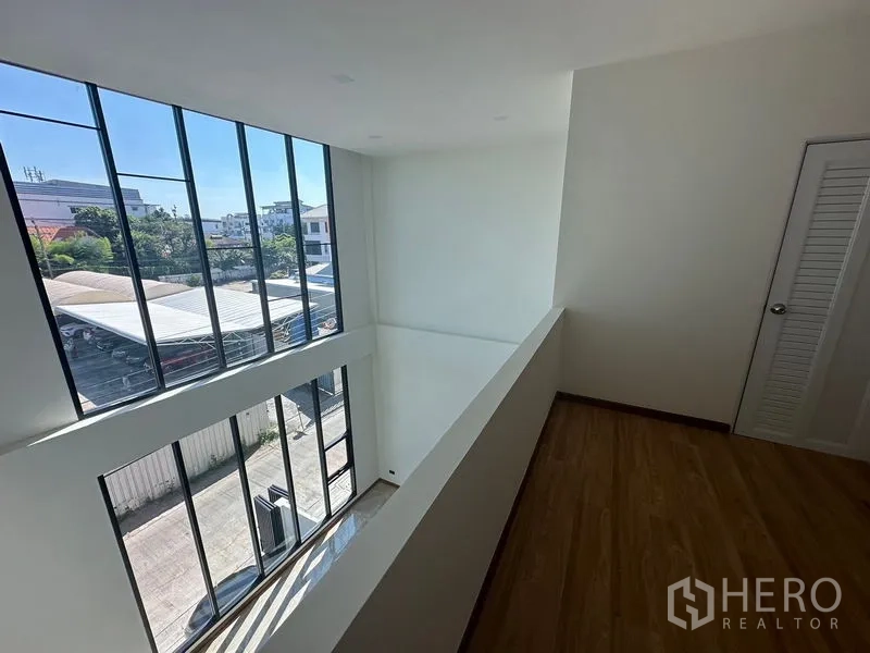 สำนักงานที่บ้าน ให้เช่าในWang Thonglang, Bangkok - มุมมองจากชั้นลอยลงสู่โถงเพดานสูงและผนังกระจกเต็มบาน