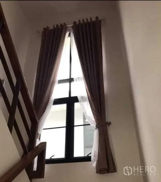 Detached House for rent or sale in Thanyaburi, Pathum Thani - Stairwell with a tall window and double curtains bringing natural light inside.