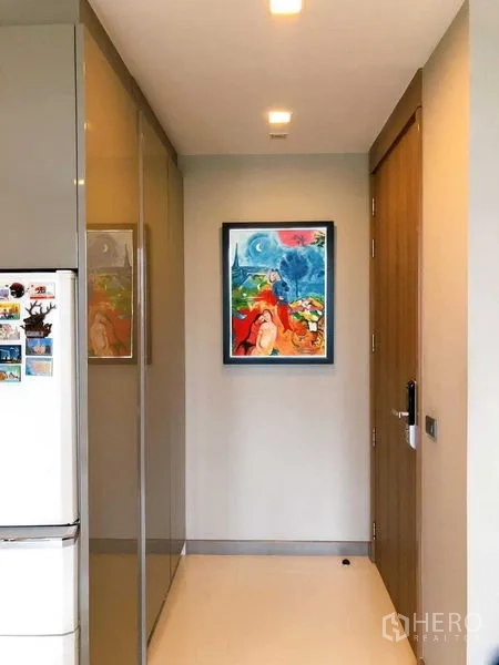 公寓 出租在Bang Rak, Bangkok - 入户走廊设嵌入式柜体与色彩鲜艳的装饰画。