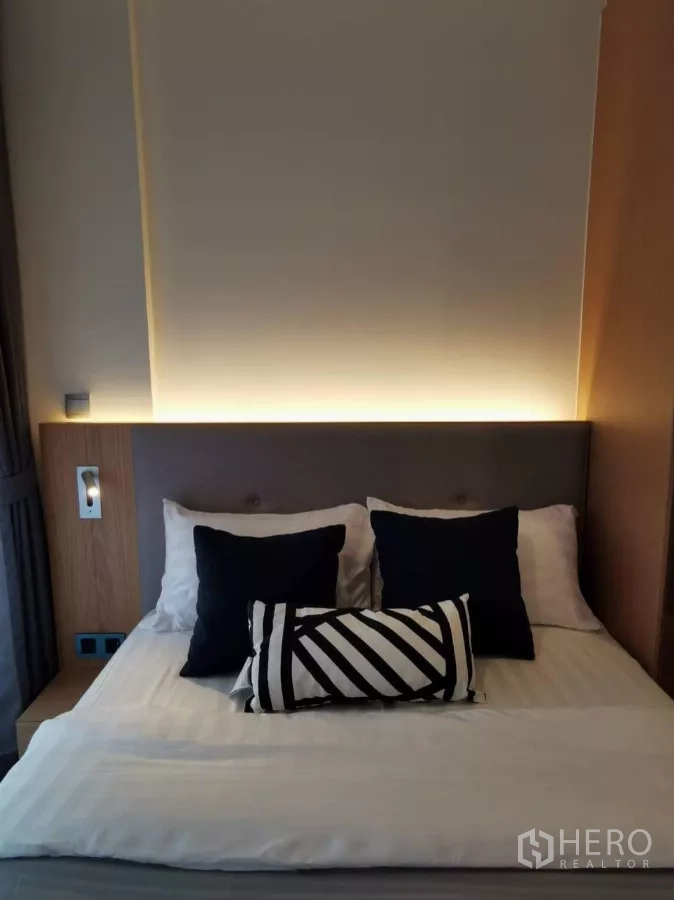 คอนโด ให้เช่าในWatthana, Bangkok - ภาพระยะใกล้ของหัวเตียงบุผ้าและไฟซ่อนสีส้มอุ่น