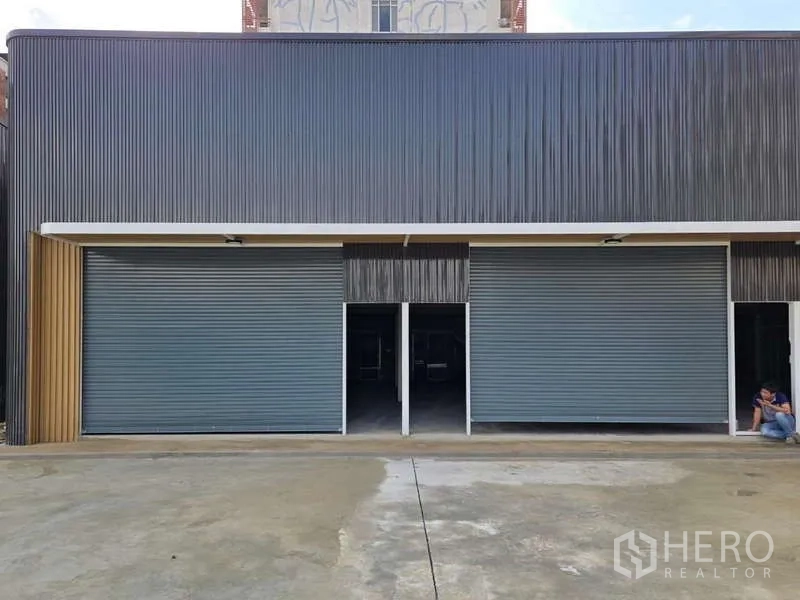 Warehouse for rent in Wang Thonglang, Bangkok - Front elevation of a warehouse unit with two roller shutters and a covered loading apron.