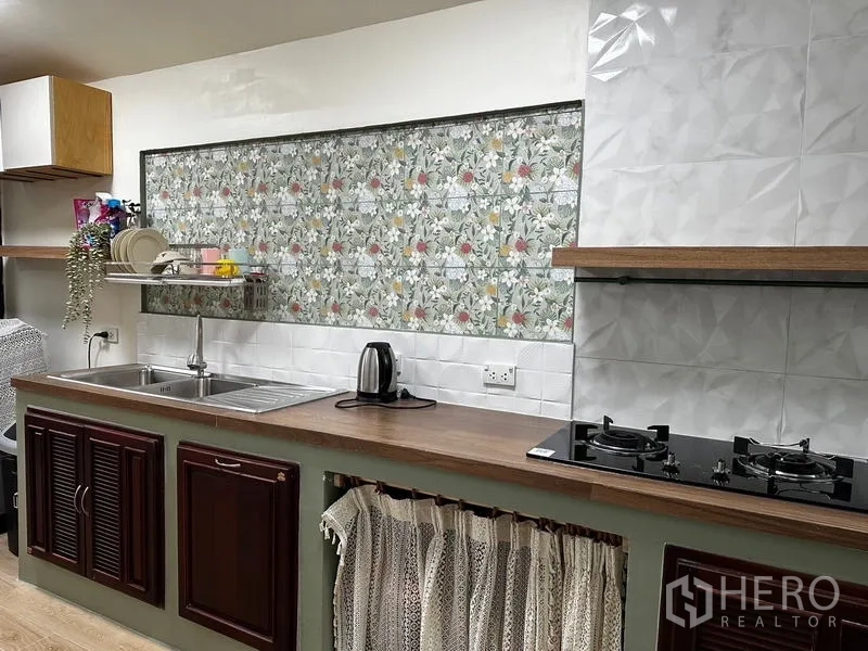 独立式住宅 出租在Prawet, Bangkok - 泰式厨房，双水槽、燃气灶与花卉图案墙砖。