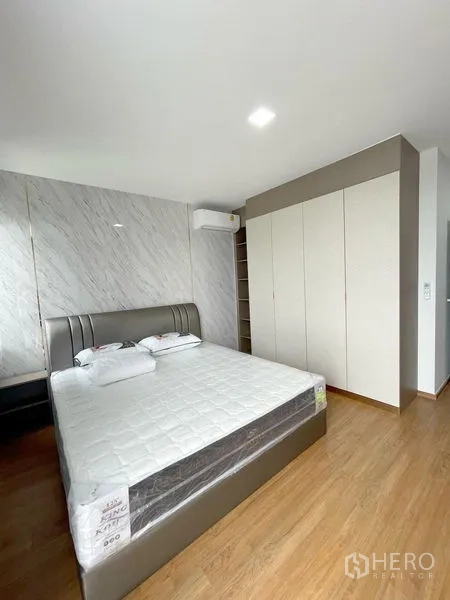 Townhouse for rent in Bang Phli, Samut Prakan - Master bedroom showing full-height wardrobe, air-conditioning and contemporary headboard.