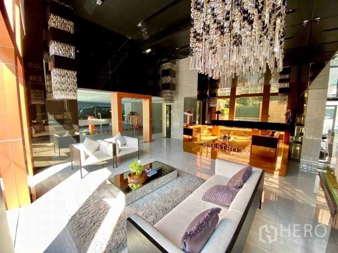 คอนโด ให้เช่าในWatthana, Bangkok - ล็อบบี้คอนโดหรู โคมระย้า เฟอร์นิเจอร์นั่งสบาย และเคาน์เตอร์ต้อนรับ