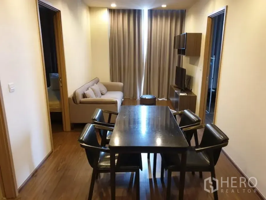 คอนโด ให้เช่าในWatthana, Bangkok - พื้นที่นั่งเล่นและทานอาหารแบบเปิด โต๊ะหกที่นั่ง โซฟา ตู้ทีวี และผ้าม่านสูงถึงเพดาน