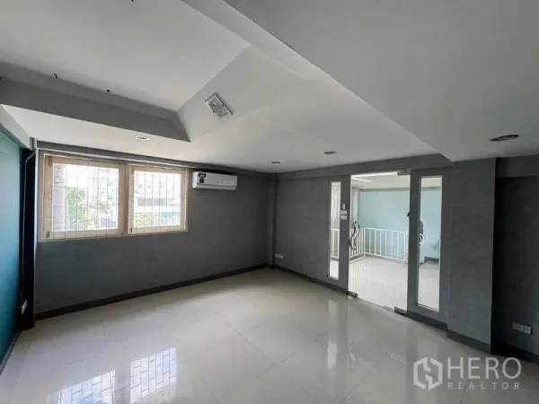 Office Space for rent in Prawet, Bangkok - Private office with windows, wall AC and glass door opening to a corridor.