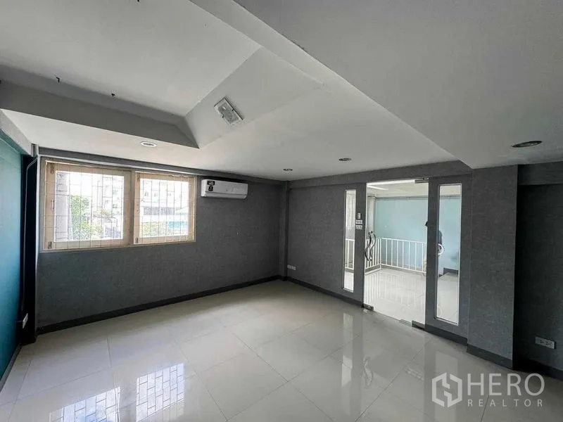 Office Space for rent in Prawet, Bangkok - Private office with windows, wall AC and glass door opening to a corridor.