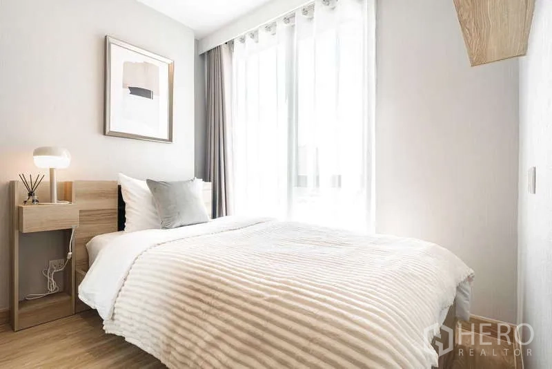 คอนโด ให้เช่า - ห้องนอนสว่างด้วยหน้าต่างเต็มบาน เตียงคู่และโต๊ะข้างเตียง