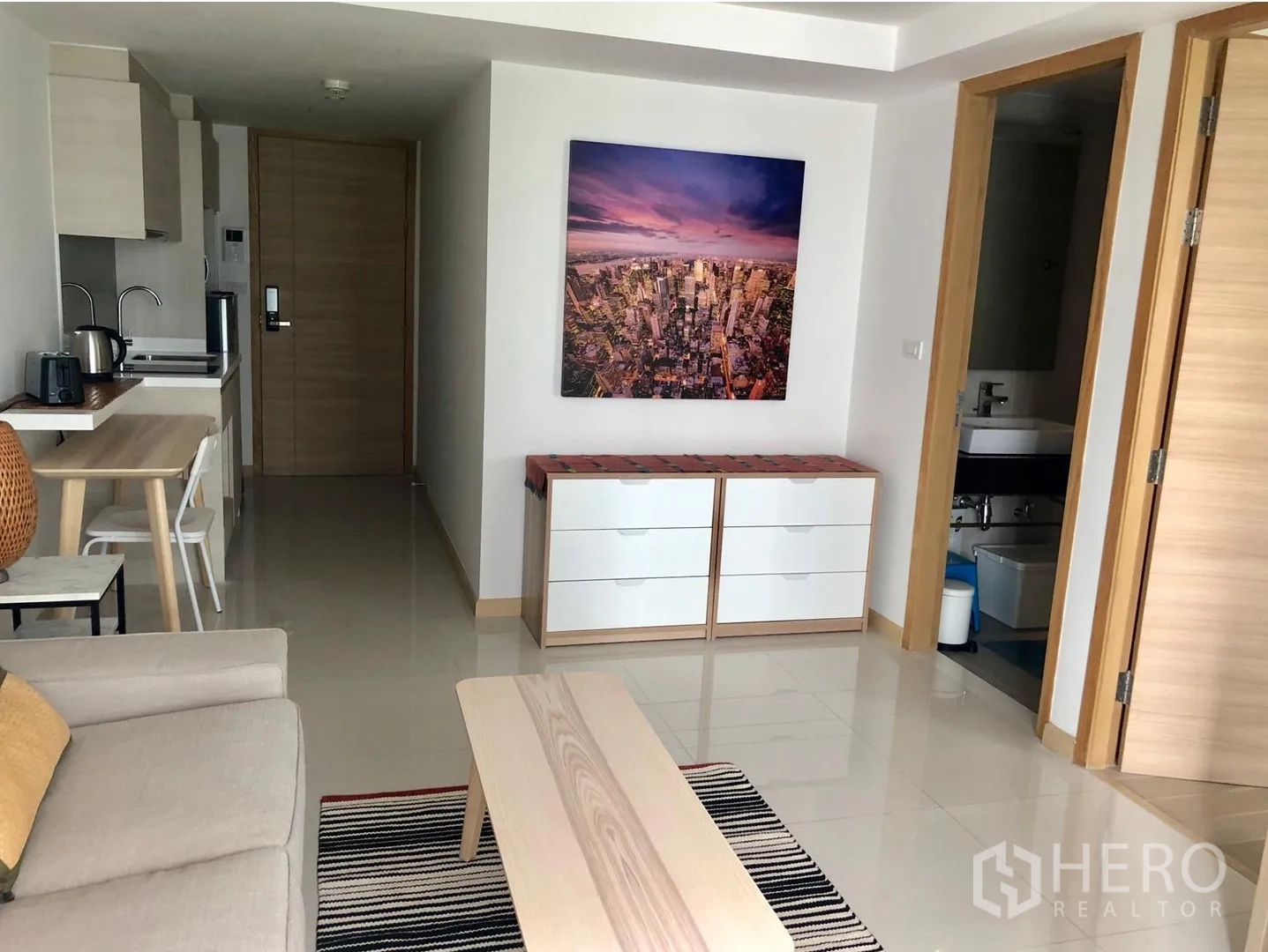 Condominium for rent in Watthana, Bangkok - Open-plan living area with storage cabinet, hallway and bathroom entrance.
