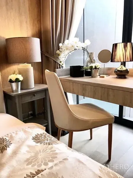 Condominium for rent in Watthana, Bangkok - Work desk by full-height window with chair, lamps, and decorative orchids.