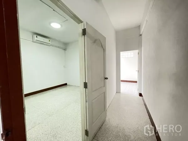带办公室的家 出租在Din Daeng, Bangkok - 带空调的房间，白色门通向走廊，墙面明亮。