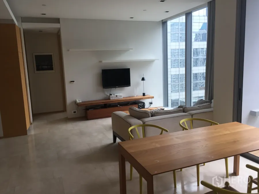 公寓 出租在Bang Rak, Bangkok - 开放式客餐厅，落地窗与城市景观，木质餐桌与舒适沙发的现代曼谷公寓。