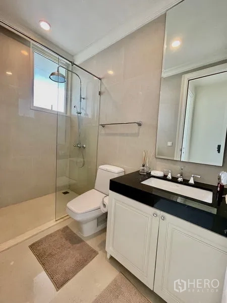 คอนโด ขายในWatthana, Bangkok - ห้องน้ำสว่าง พร้อมตู้กระจกอาบน้ำ ฝักบัวเรนชาวเวอร์ และเคาน์เตอร์ท็อปหินสีดำ