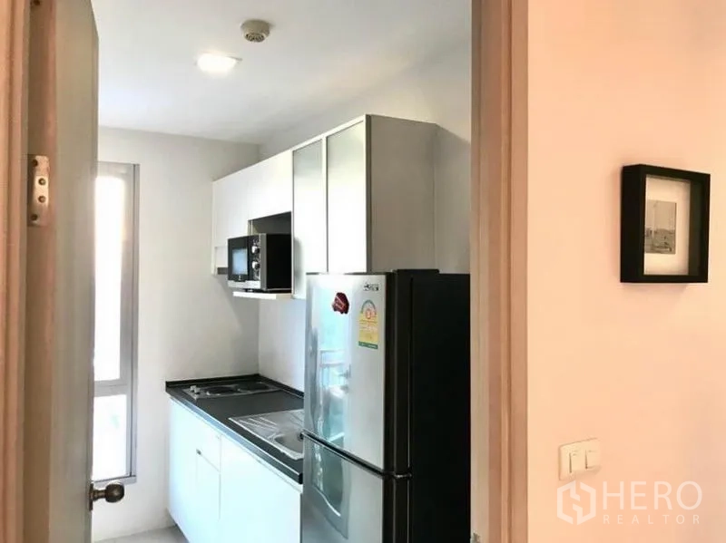 คอนโด ให้เช่าในHuai Khwang, Bangkok - ครัวแยกขนาดกะทัดรัด มีหน้าต่าง ตู้เก็บของ เตา ไมโครเวฟ และตู้เย็น