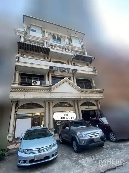 Shophouse for rent - Four-storey shophouse exterior with classical columns, arched frontage, balconies and on-site parking with cars in the Sukhumvit Nana area of Bangkok.