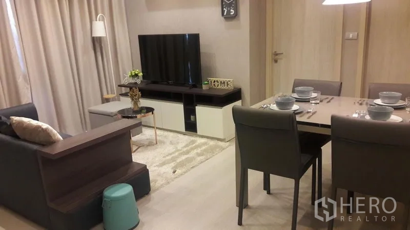 Condominium for rent in Khlong Toei, Bangkok - Living and dining area with TV console, rug, and dining set