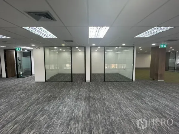 Office Space for rent in Khlong Toei, Bangkok - Open-plan office with carpet tiles and three glass-partitioned rooms.