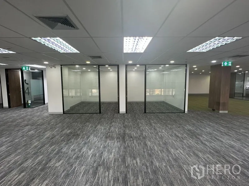 Office Space for rent in Khlong Toei, Bangkok - Open-plan office with carpet tiles and three glass-partitioned rooms.