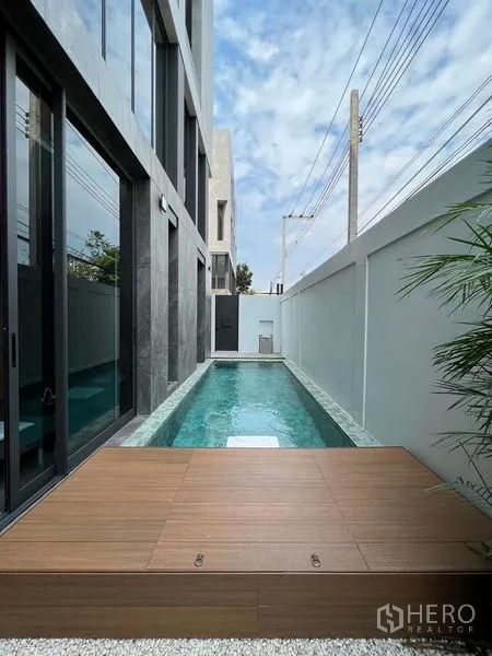 Home Office for sale in Prawet, Bangkok - Private narrow lap pool beside the building with a wood deck and high privacy wall.
