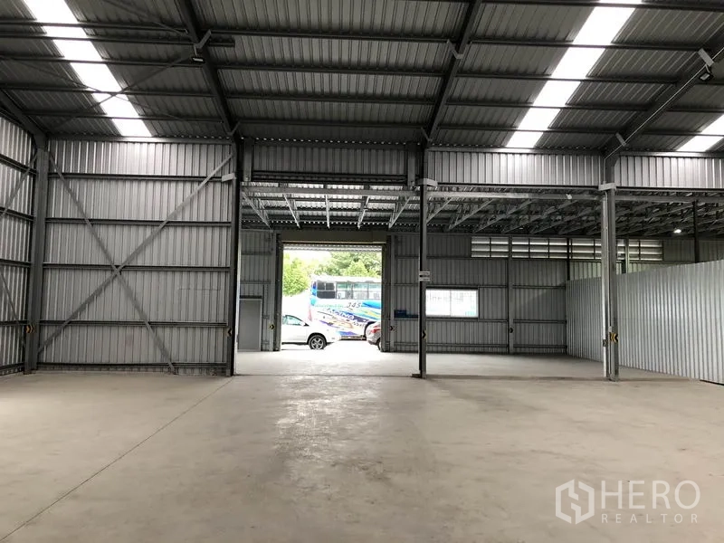 Warehouse for rent in Pak Kret, Nonthaburi - Interior looking toward twin loading openings with natural light from roof panels.