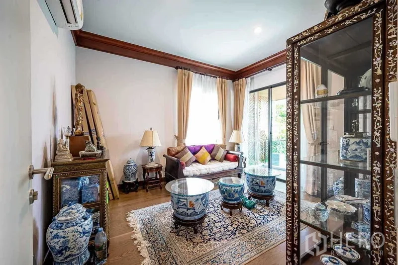 บ้าน ขายในPrawet, Bangkok - ห้องนั่งเล่นสไตล์ไทย ตู้โชว์กระจกและเครื่องปั้นดินเผา ใกล้ประตูกระจกบานเลื่อน.