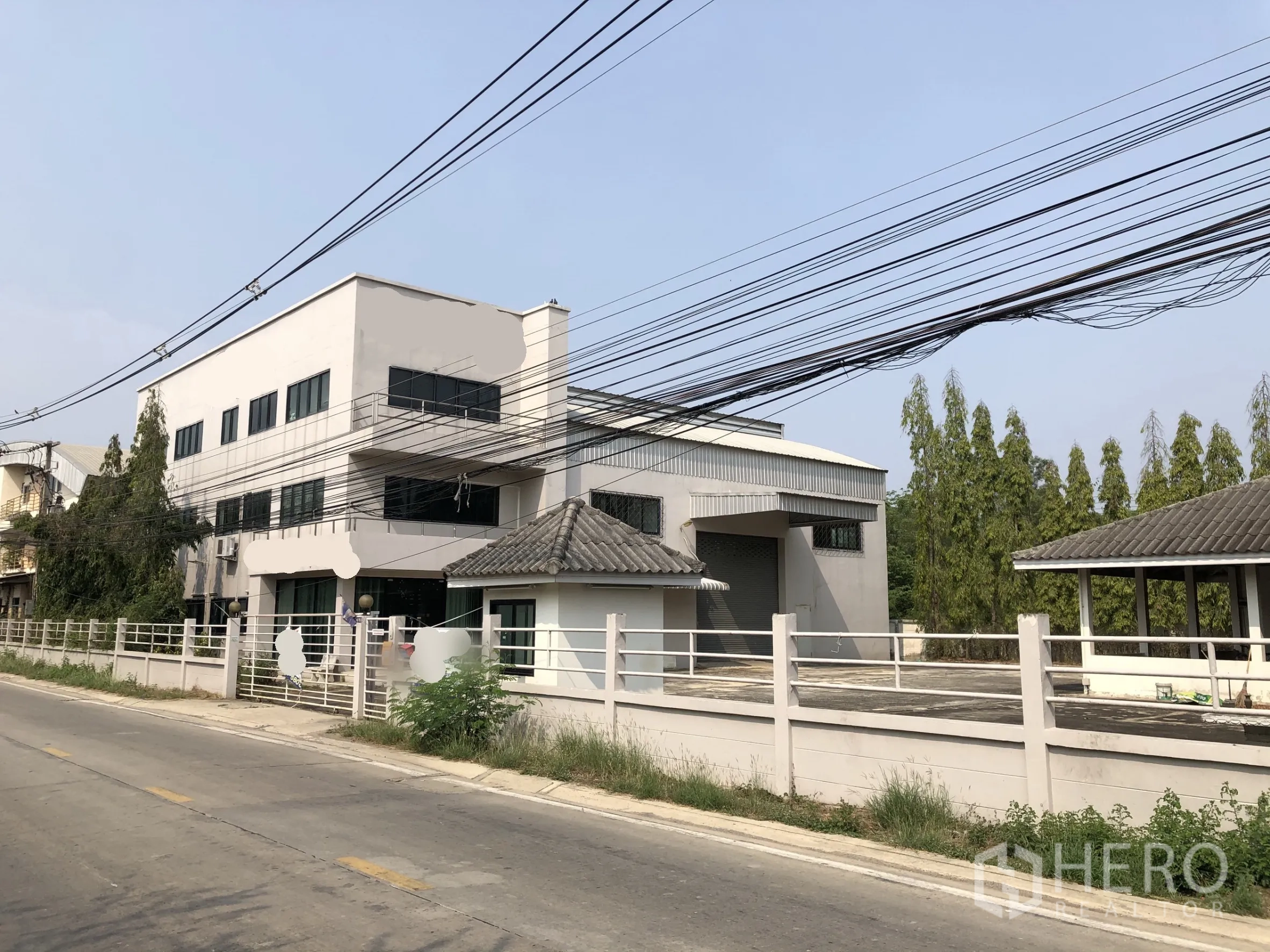 โรงงาน ขายในLam Luk Ka, Pathum Thani - มุมมองด้านหน้าโรงงานสมัยใหม่ มีอาคารสำนักงาน ลานโหลด และรั้วรอบริมถนนเงียบสงบ