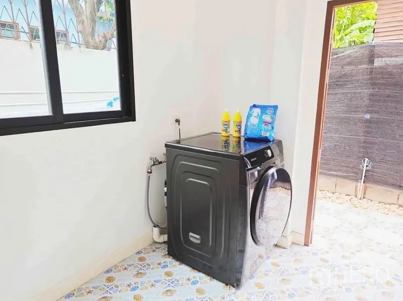 Detached House for rent - Laundry area with a front-load washer and access to a small yard.