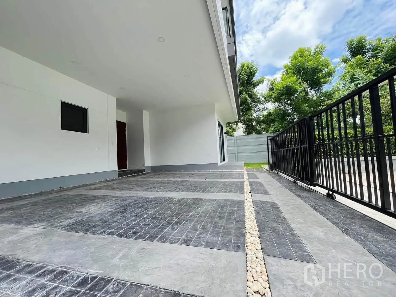 บ้านเดี่ยว for rent or sale in Prawet, Bangkok - ที่จอดรถมีหลังคาพร้อมประตูรั้ว และแนวสวนริมรั้วต้นไม้