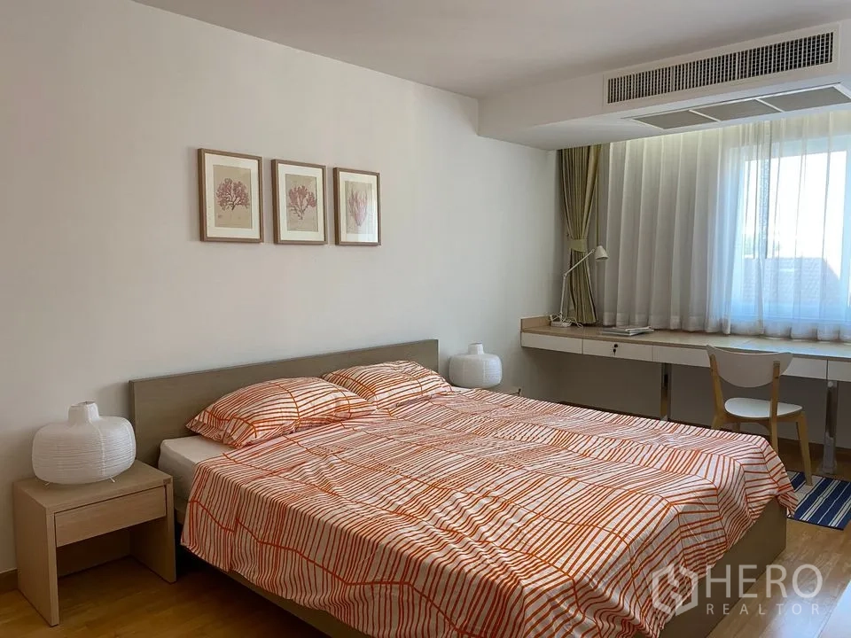 Condominium for rent or sale in Phra Khanong, Bangkok - Second bedroom with king bed and long built-in study desk beneath a wide window.