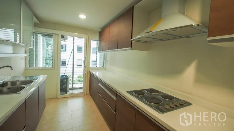 คอนโด ให้เช่าในKhlong San, Bangkok - มุมครัวอีกด้านพร้อมเตาไฟฟ้า เครื่องดูดควัน เคาน์เตอร์ยาว และทางออกระเบียง