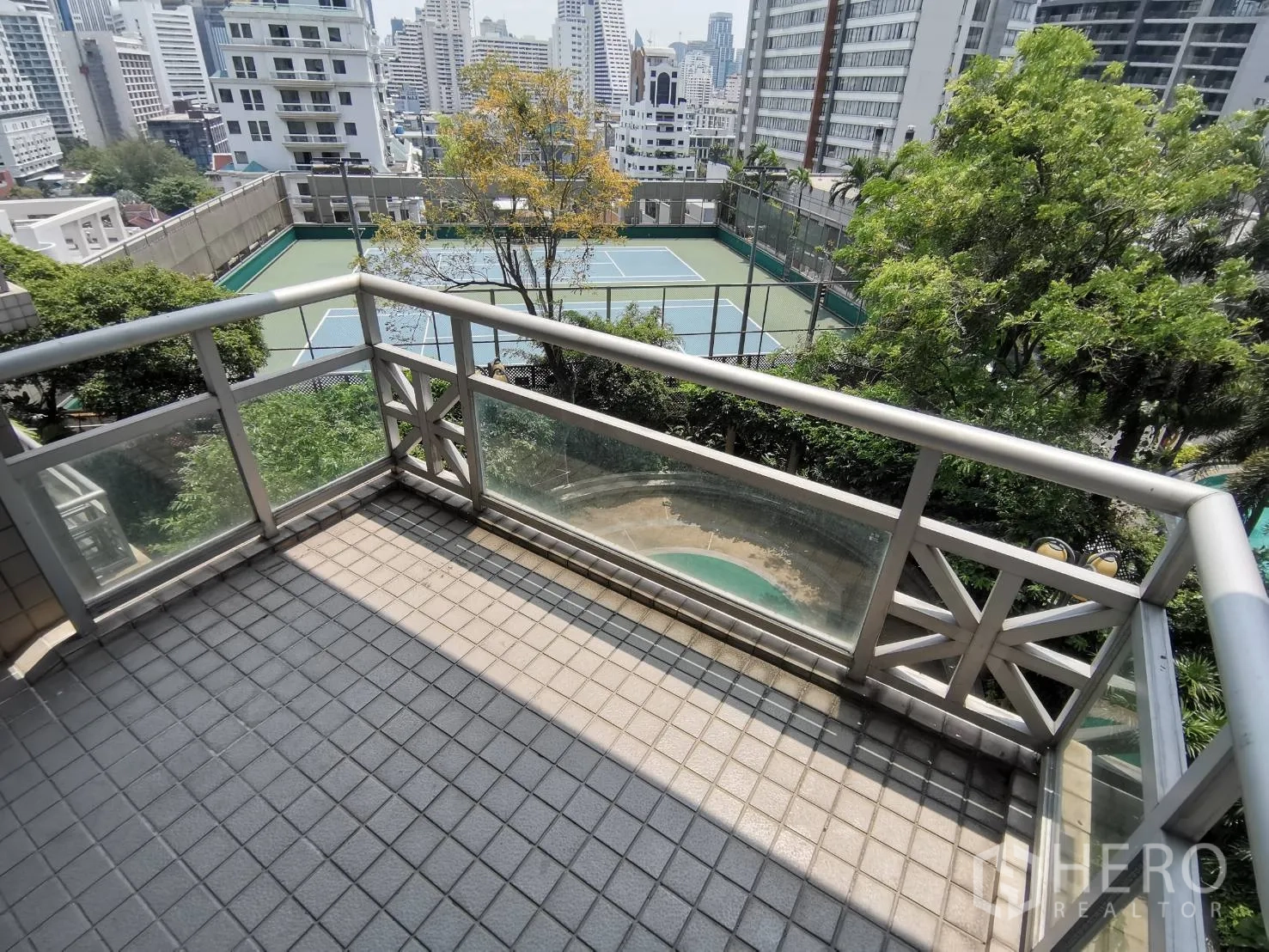 คอนโด ให้เช่าในPathum Wan, Bangkok - ระเบียงหันไปทางสนามเทนนิส พร้อมพื้นกระเบื้องและราวกันตกกระจก มุมมองสกายไลน์