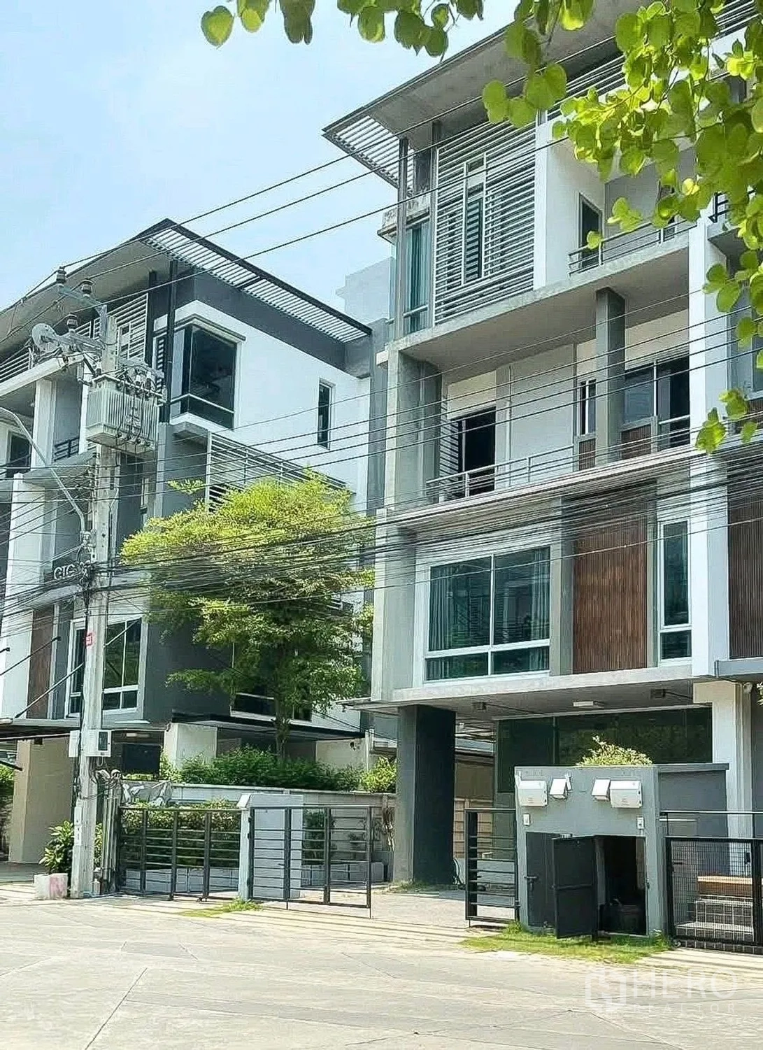 家庭办公室 for rent or sale in Wang Thonglang, Bangkok - 街景，现代联排式建筑与绿植。