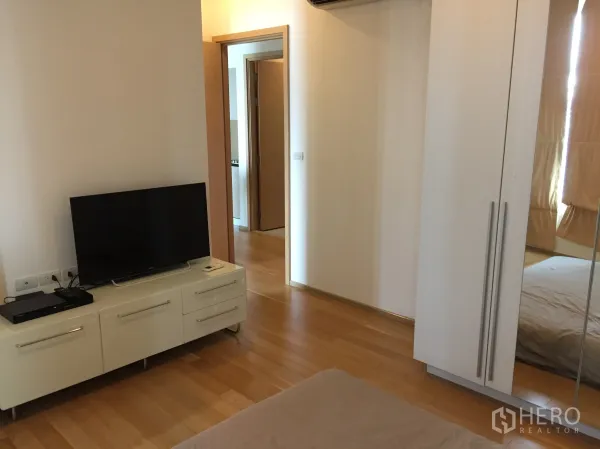 คอนโด ให้เช่าในWatthana, Bangkok - ห้องนอนพร้อมตู้วางทีวี ตู้เสื้อผ้า และพื้นไม้โทนอ่อน