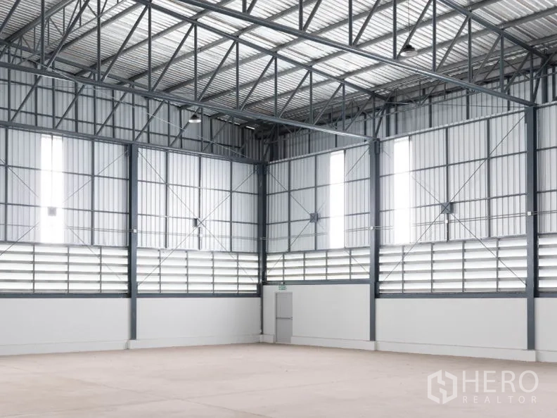 工厂 出租在Si Racha, Chon Buri - 厂房内角落，高窗与通风百叶、钢结构立柱