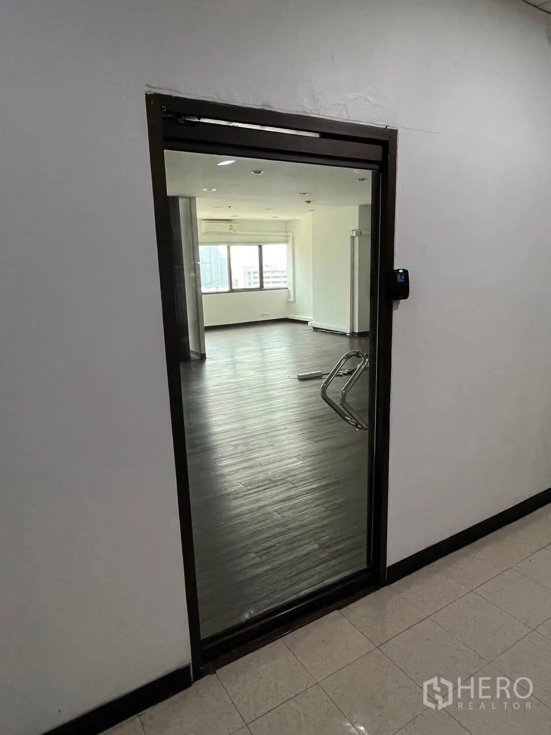 ออฟฟิศ for rent in Watthana, Bangkok - ประตูกระจกพร้อมระบบคีย์การ์ด เปิดสู่สำนักงานสว่างพื้นลายไม้.