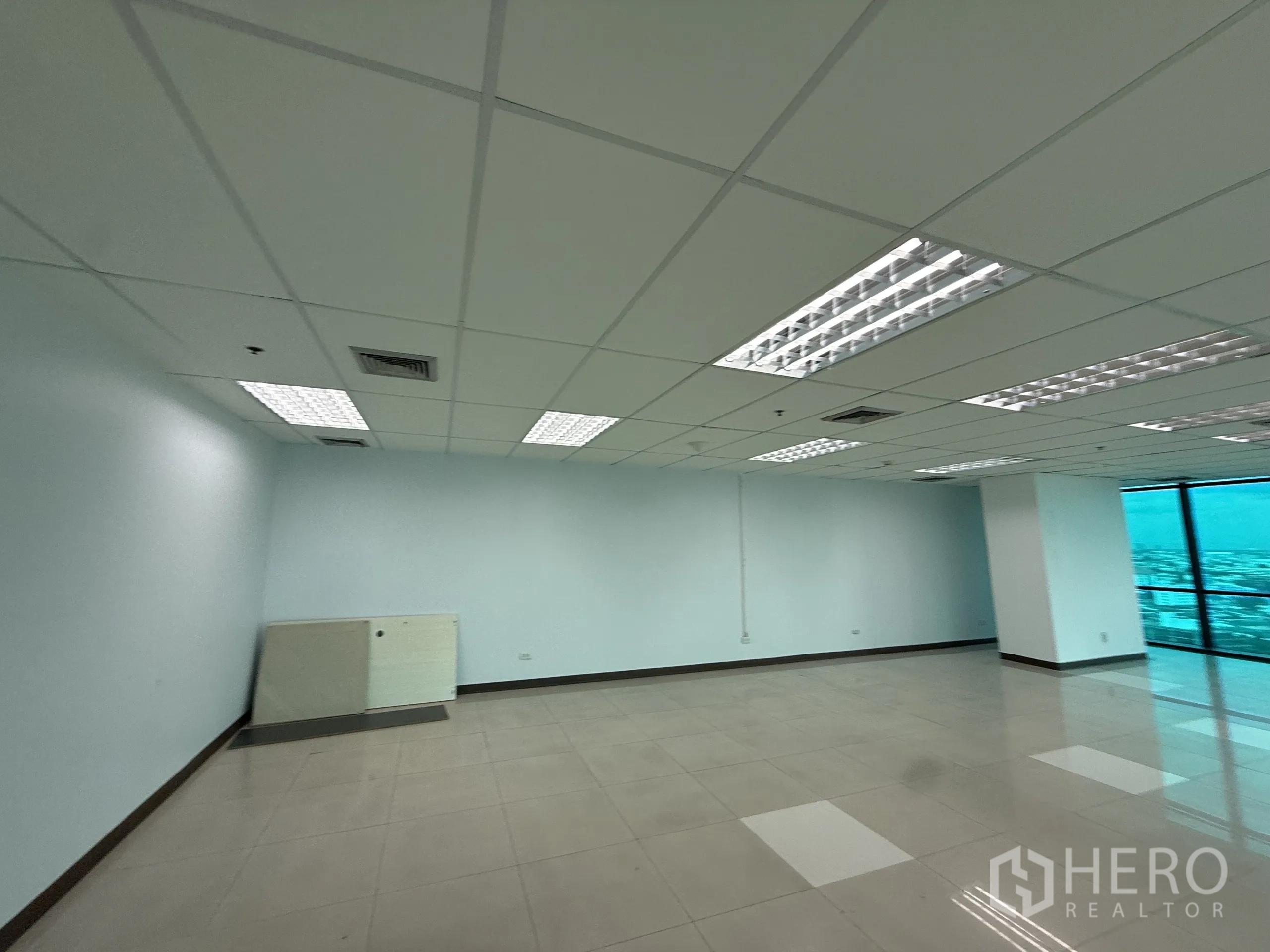 สำนักงาน ให้เช่าในHuai Khwang, Bangkok - พื้นที่สำนักงานผนังสีขาวกว้าง เพดานแขวนไฟฟลูออเรสเซนต์ ช่องลมแอร์ และแนวหน้าต่างด้านขวา