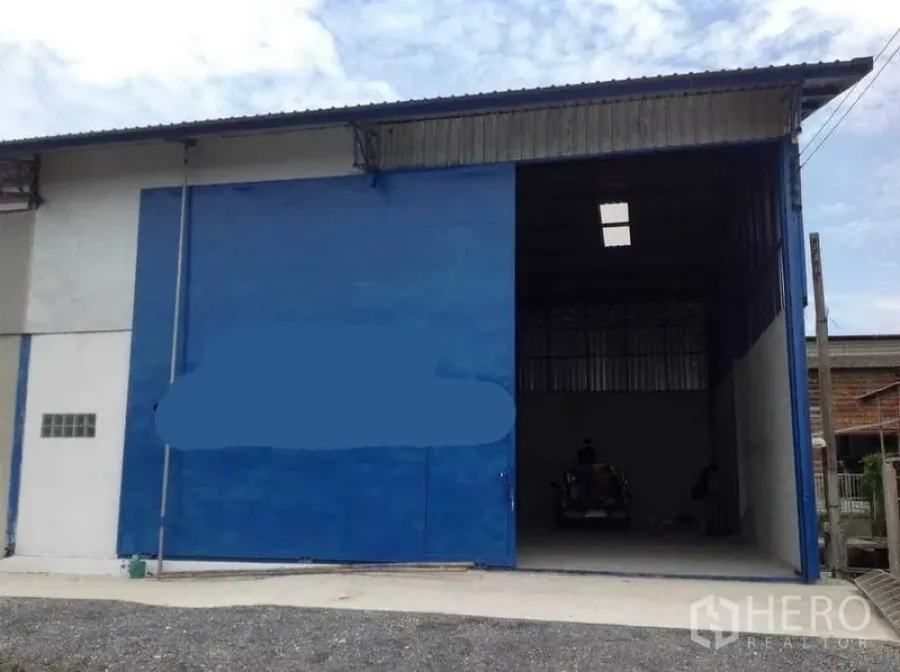 工厂 出租在Mueang Nakhon Pathom, Nakhon Pathom - 工厂正立面，超高蓝色推拉门打开，便于卡车装卸。